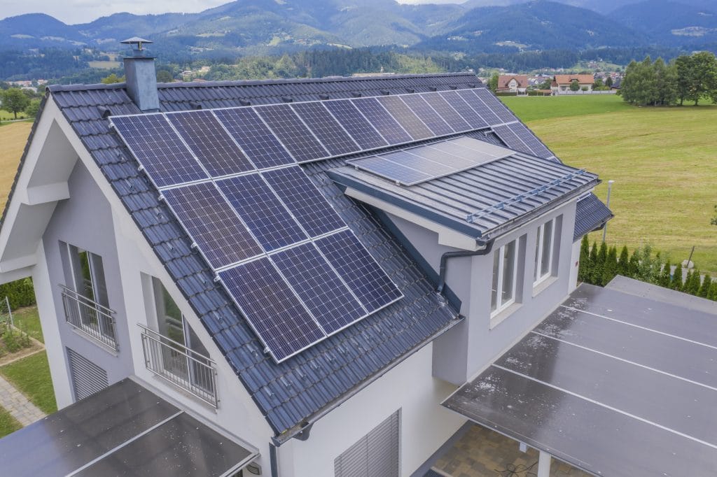 maison située dans une vallée avec des panneaux solaires sur le toit